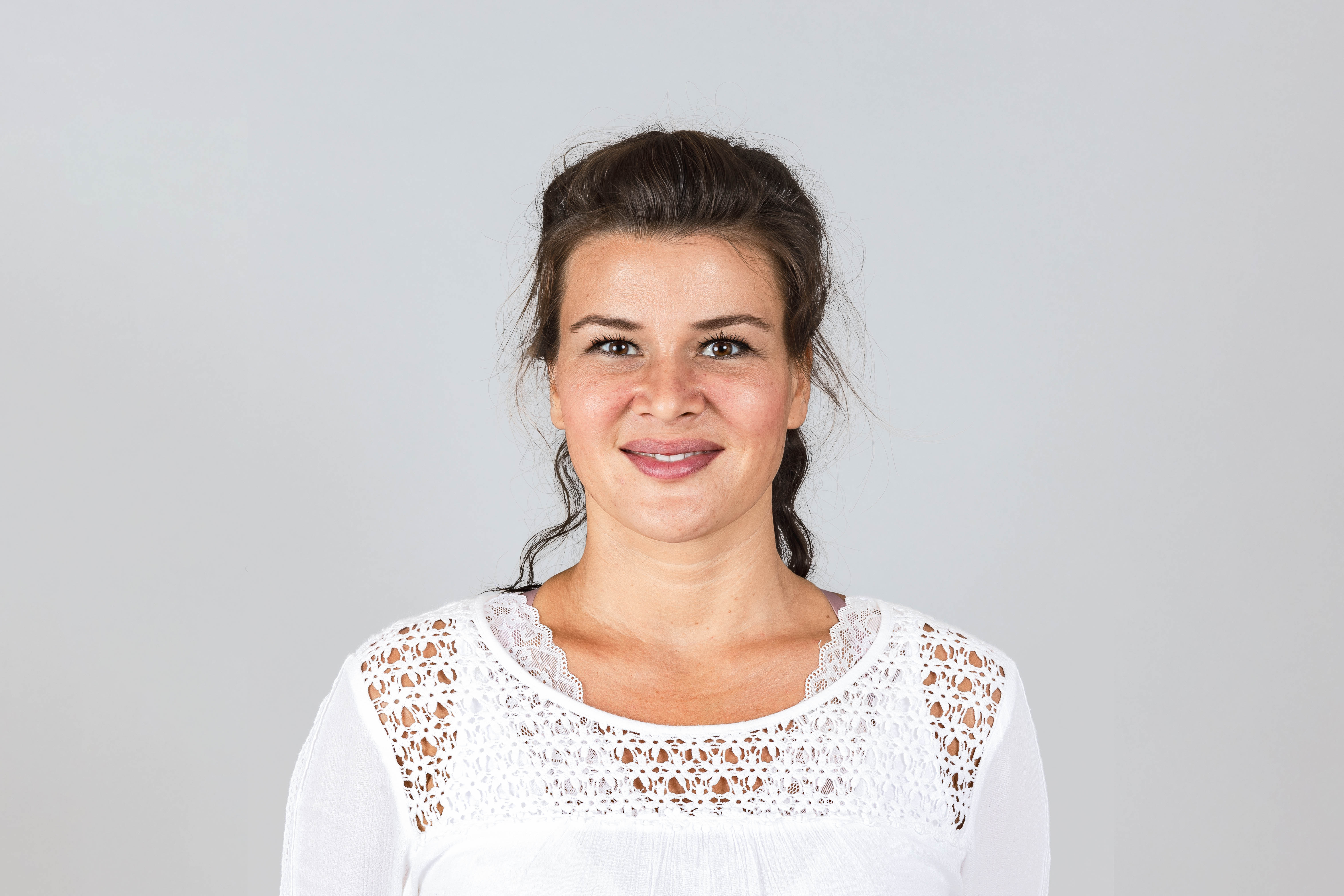 Ein Portraitfoto von Jasmina vor einem grauen Hintergrund